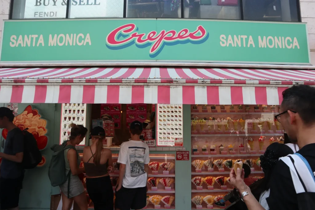 People standing in front of the Santa Monica Crepes storefront with colorful crepe displays