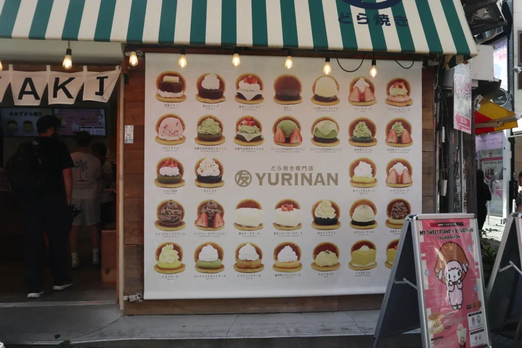 A large storefront menu showing assorted dorayaki sweets outside a shop