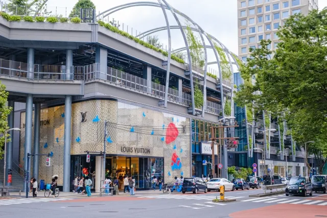 Street-level view of Miyashita Park with shops and greenery above the sidewalk