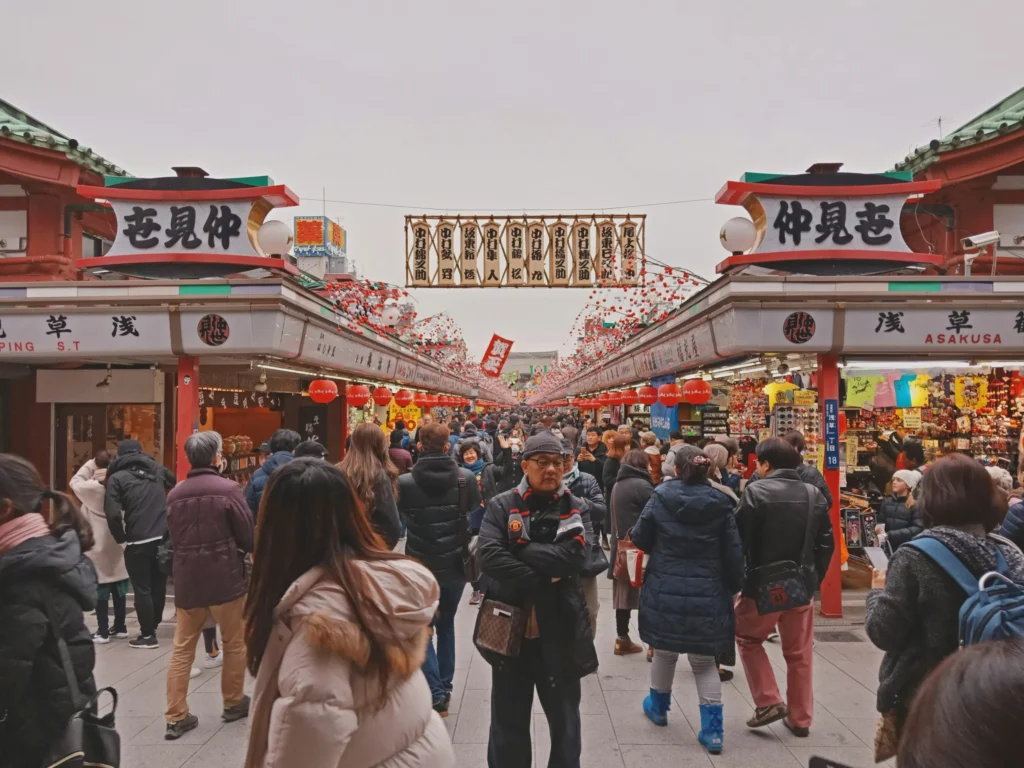 Crowds walking through the entrance of Nakamise Shopping Street in Asakusa