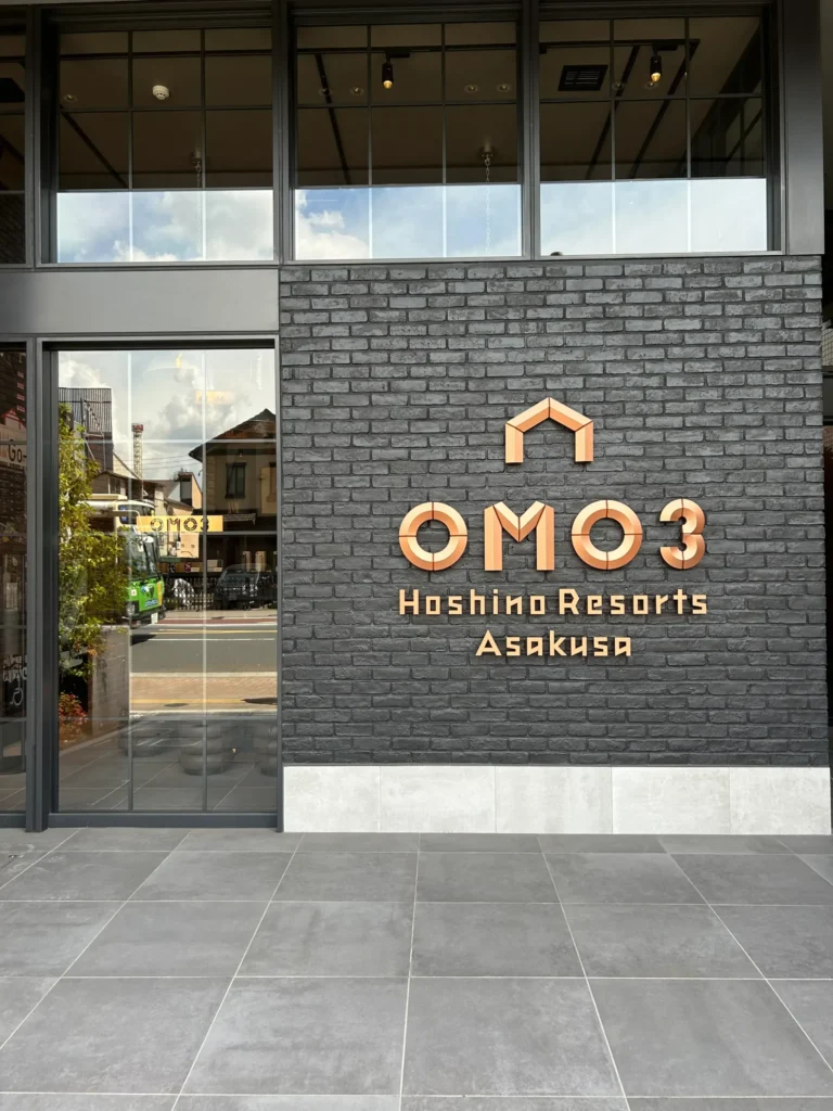 Entrance of OMO3 Asakusa by Hoshino Resorts with its logo displayed on a brick wall