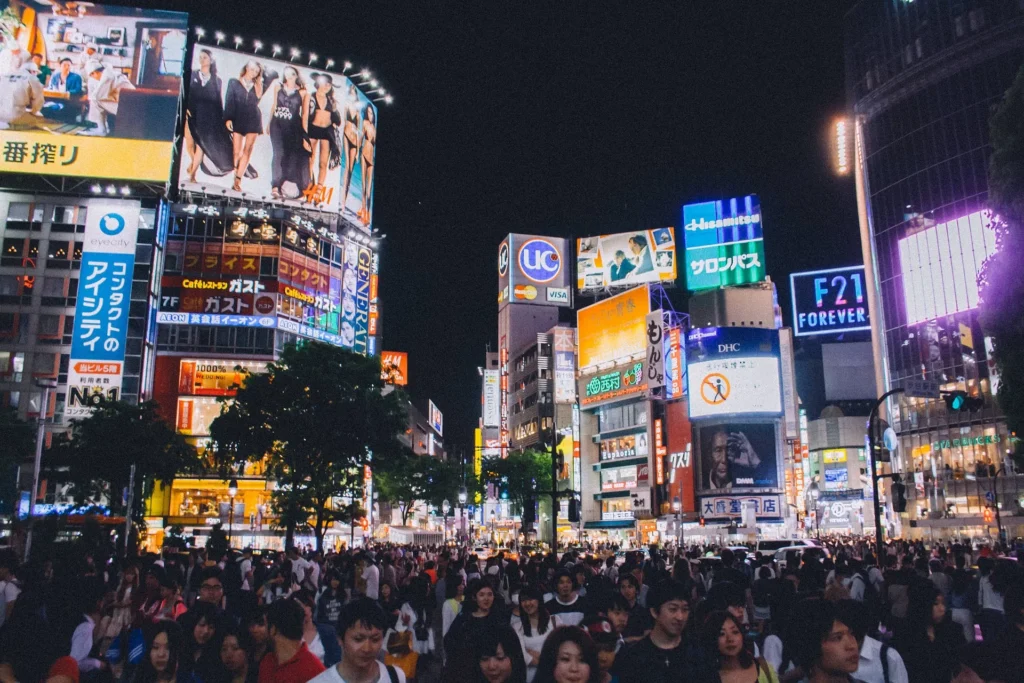 Crowds and bright signs around Shibuya Scramble Crossing at night