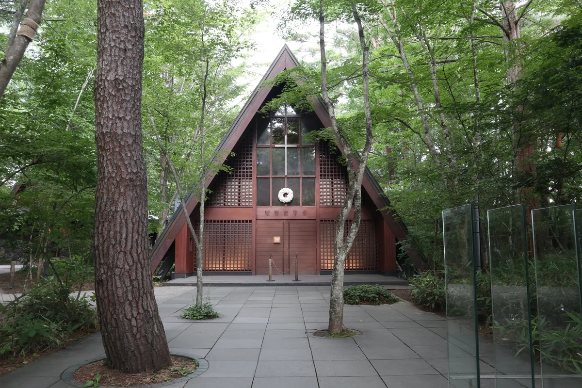 Exterior of Karuizawa Kogen Church surrounded by trees.