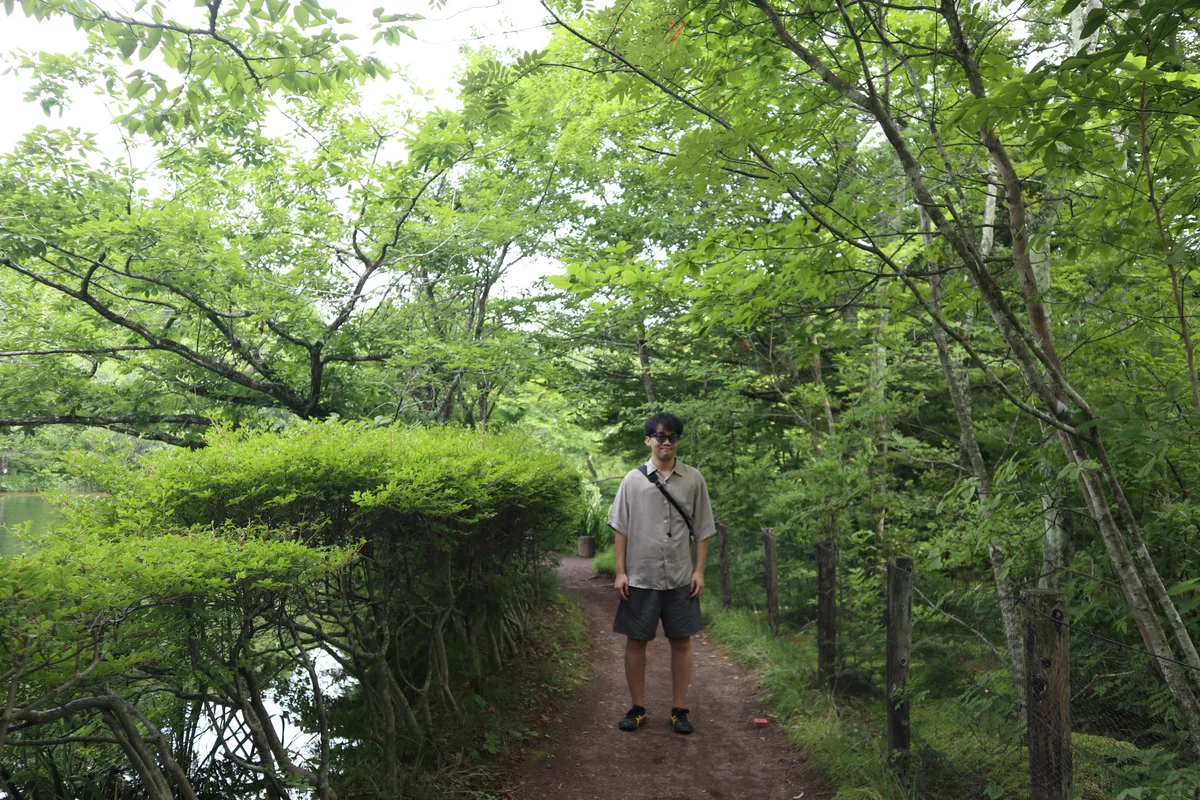 Walking path surrounded by greenery near Kumoba Pond.